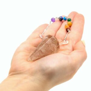 Péndulo de orgonita con cuarzo rosa y cuentas de chakras en mano
